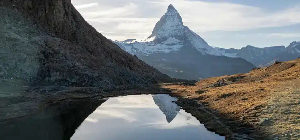 ein tiefblauer Gebirgssee umringt von Bergen mit dem Matterhorn im Hintergrund