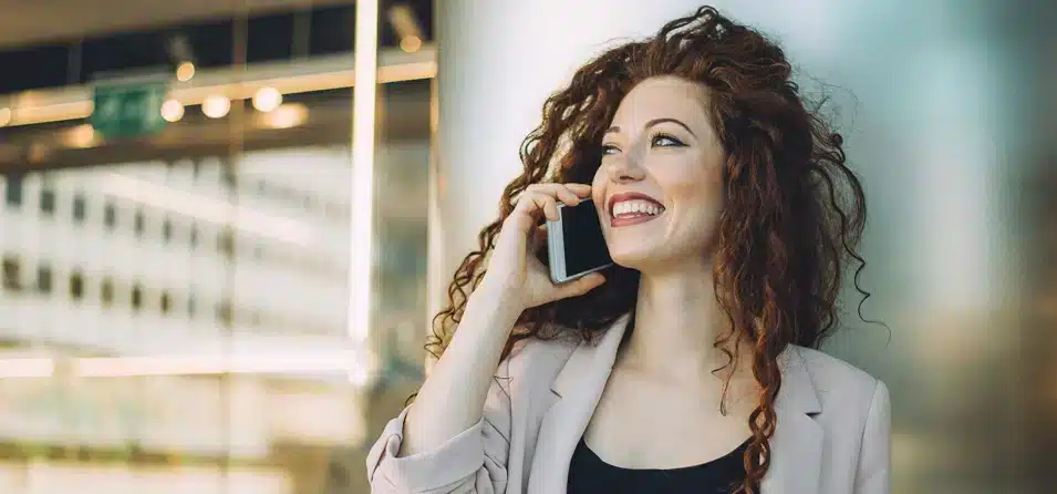 eine lächelnde Frau am Telefon