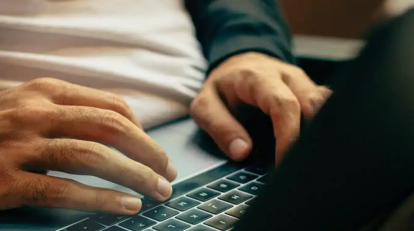 Hände die auf einer Laptop Tastatur schreiben